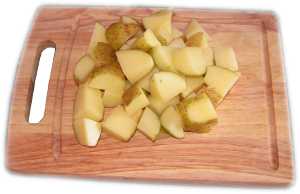ziemniaki pokrojone w kostk na desce do krojenia